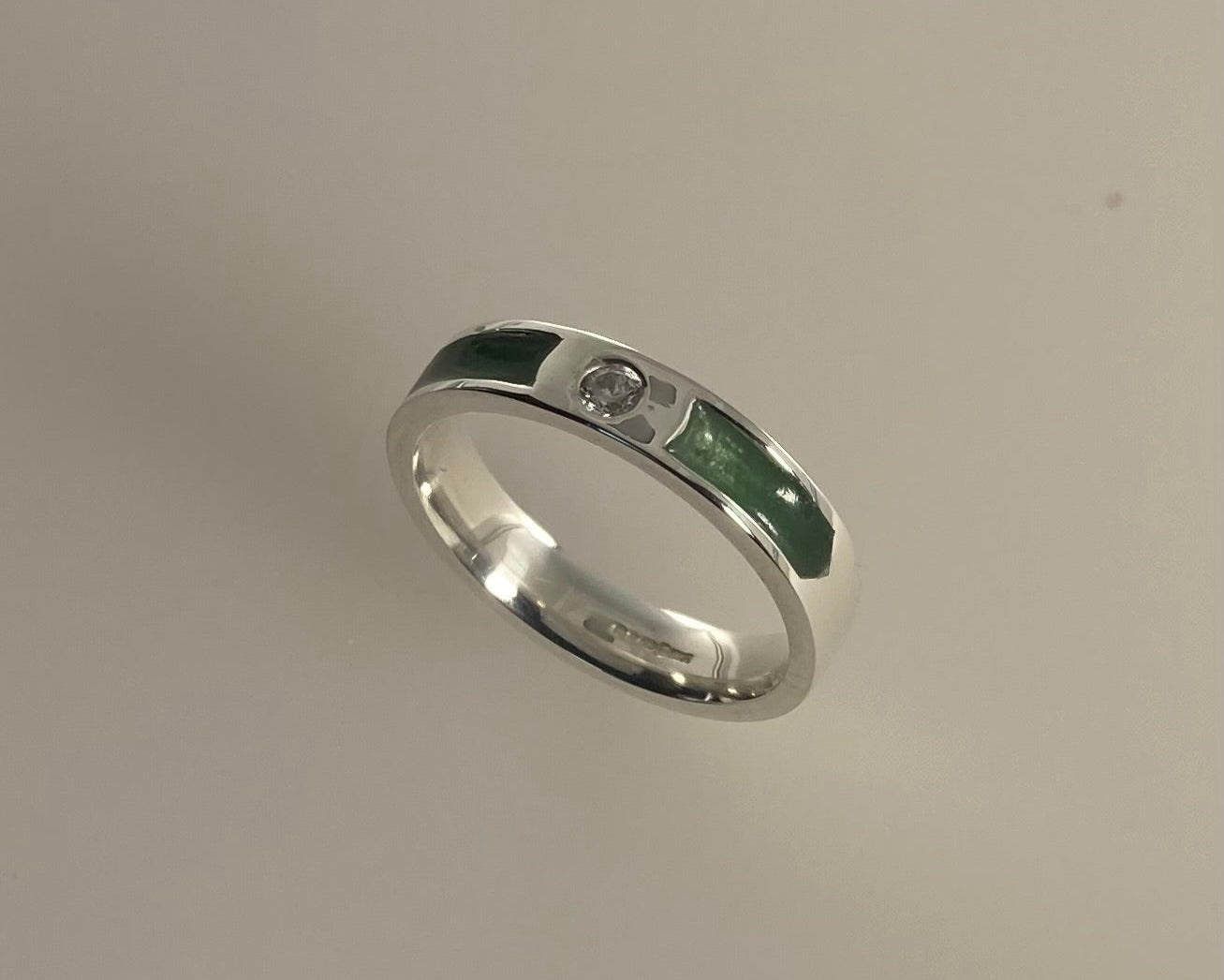 Single brilliant cut stone set in rub over 4mm wide ring with ashes in resin