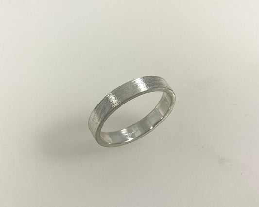 Simple bark texture 4mm wide flat ring with hidden ashes inside shank .